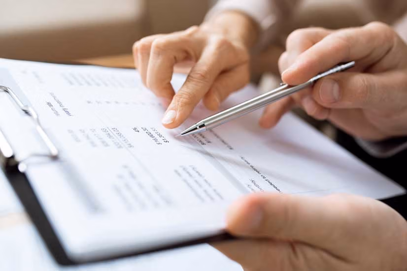 An older couple looking at a paper with a pen