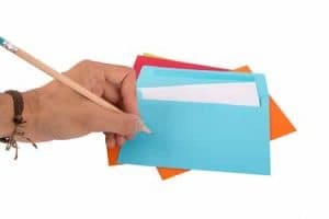 A woman writing down on an envelope