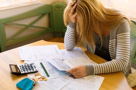 posts-foreclosure-mortgage-delinquency - Harold Shepley & Associates, LLC A woman looking at papers with a calculator