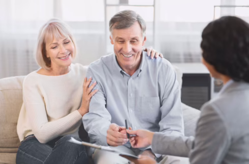 An old woman and an older man smiling at a paper they need to sign